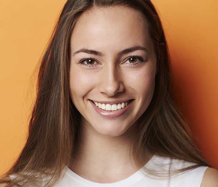 Portrait of beautiful brunette in orange studio